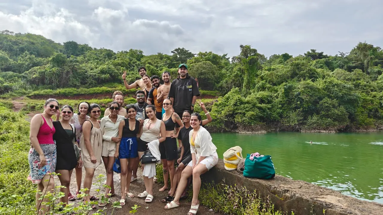 A Goa Unseen group beside a hidden emerald lake ringed by jungle