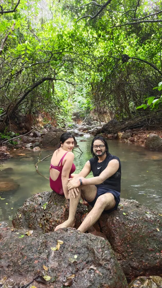 Two travellers resting on a rock in a jungle stream
